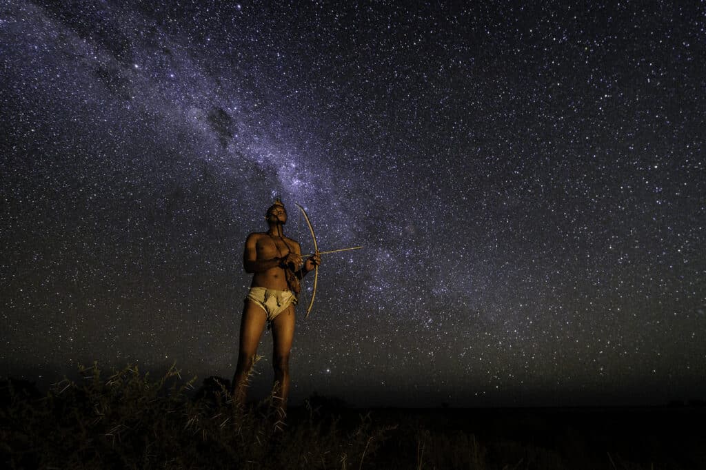 Bushmen chassant sous une nuit étoilée dans le Kalahari.
