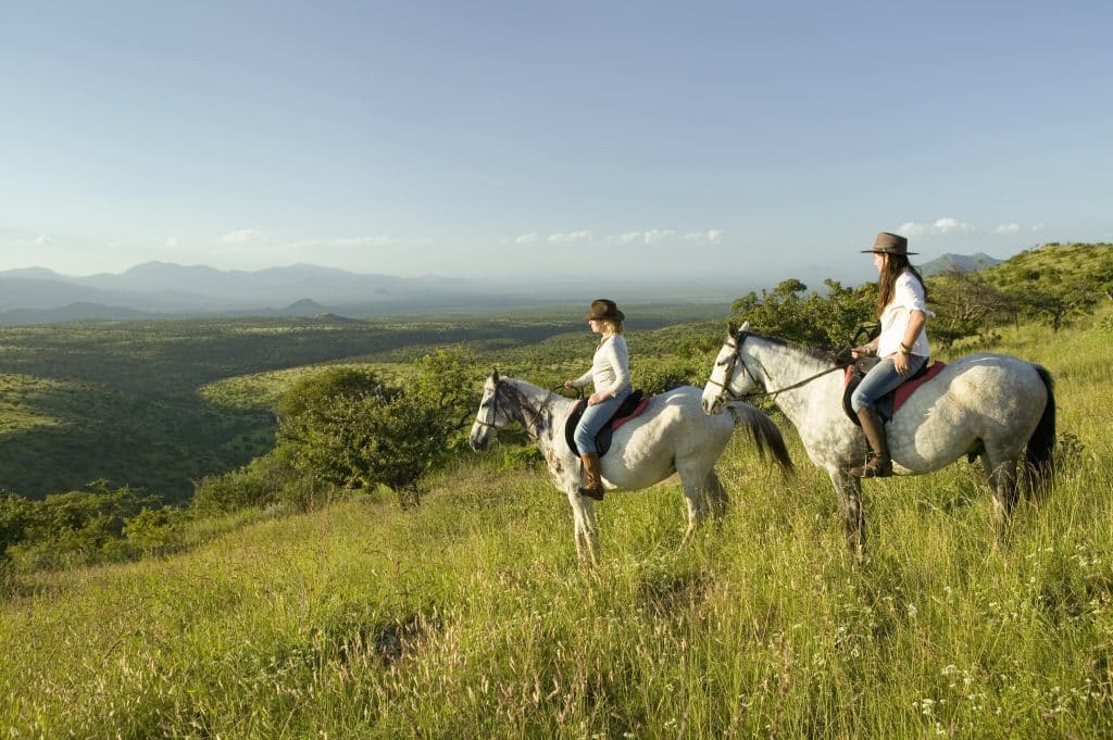 Two,Female,Horseback,Riders,On,Horseback,Ride,At,Sunset,As
