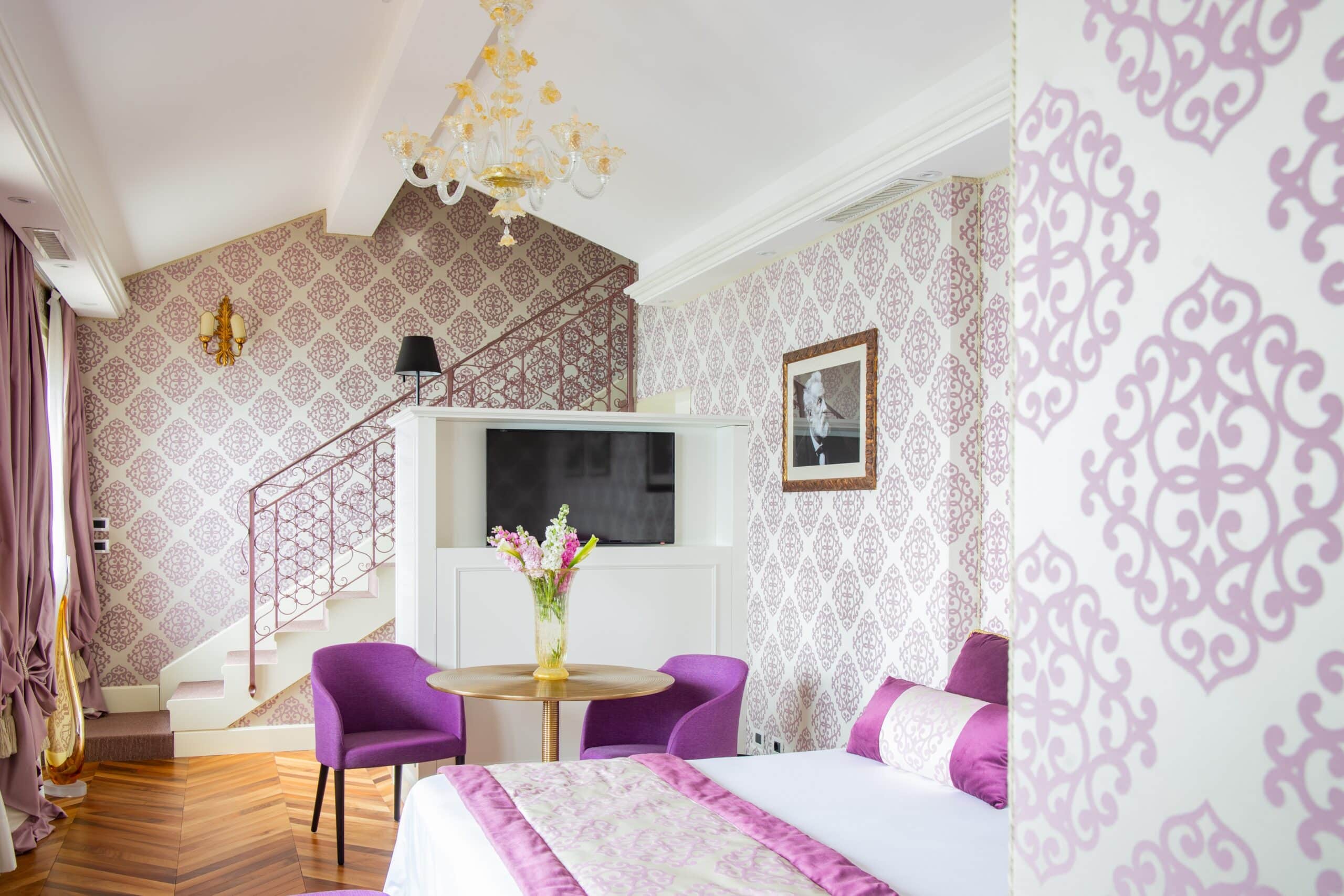 Chambre rose avec escalier en fonds à l'hôtel Londra Palace en Italie.