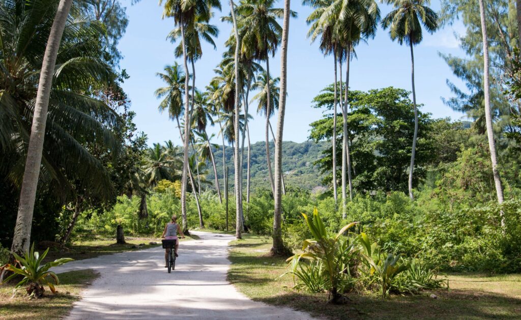 Woman,Bicycling,On,La,Digue,,Seychelles
