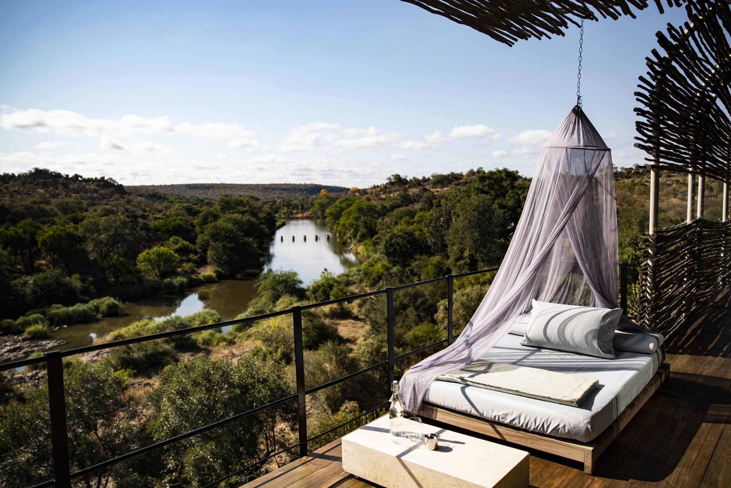 Chambre avec lit en extérieure donnant une vue sur une rivière au Singita Lebombo Lodge