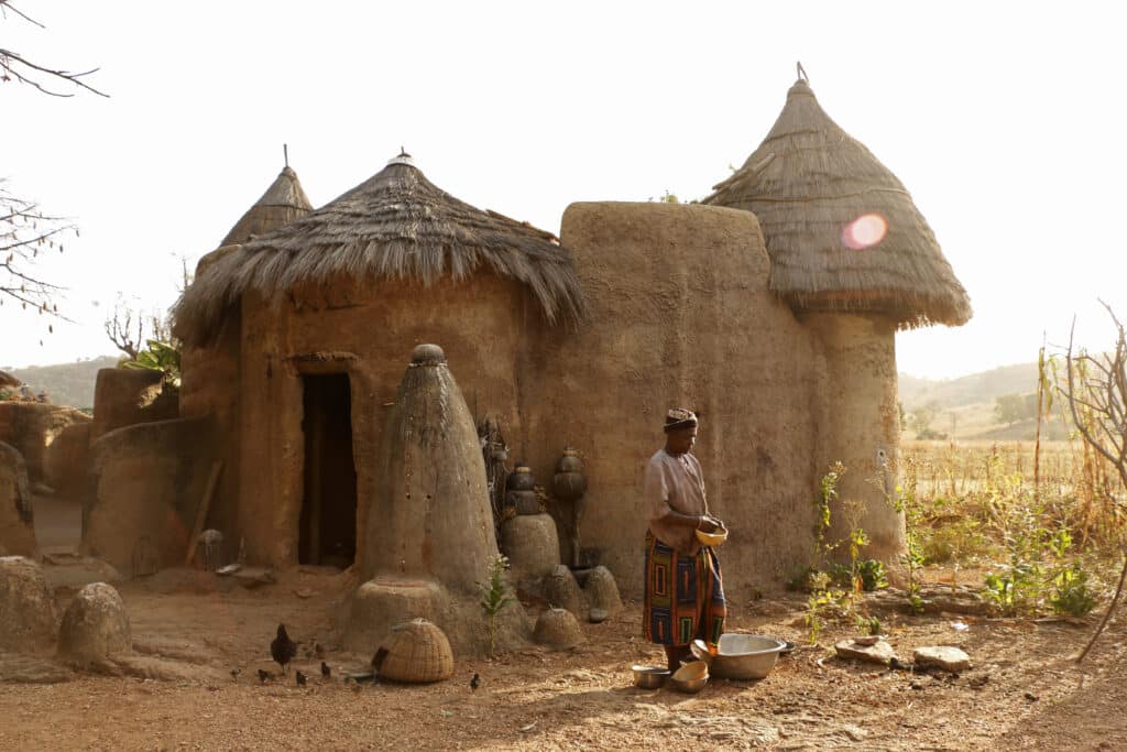 Béninois devant une habitation traditionnelle Tata Somba au Bénin.