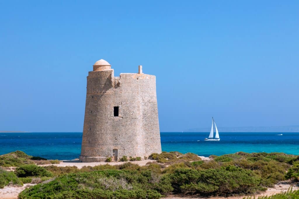 ancienne tour d'observation Torre De Ses Portes et yacht de voile au large de l'île d'Ibiza