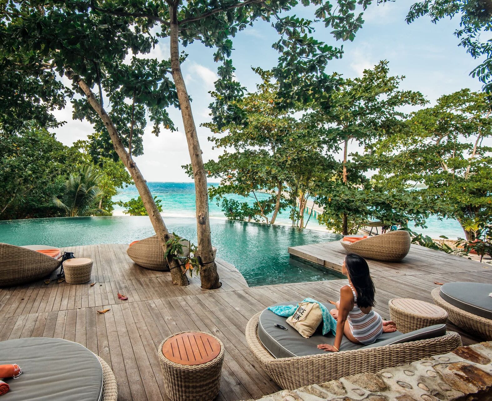 Moment de détente au bord de la piscine pour une voyageuse résidant au Bawah Reserve Hotel.