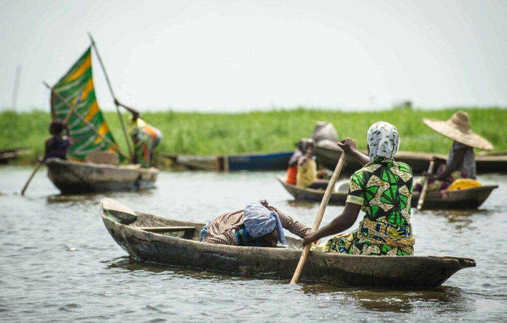 Femmes béninoises pagayant sur le lac Nokoué depuis la cité lacustre de Ganvié au Bénin.