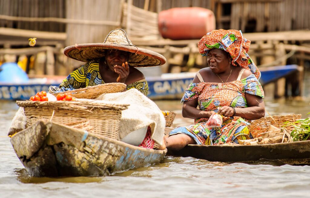 Deux femmes sur des barques discutant lors le marché du lac Ahémé au Benin.