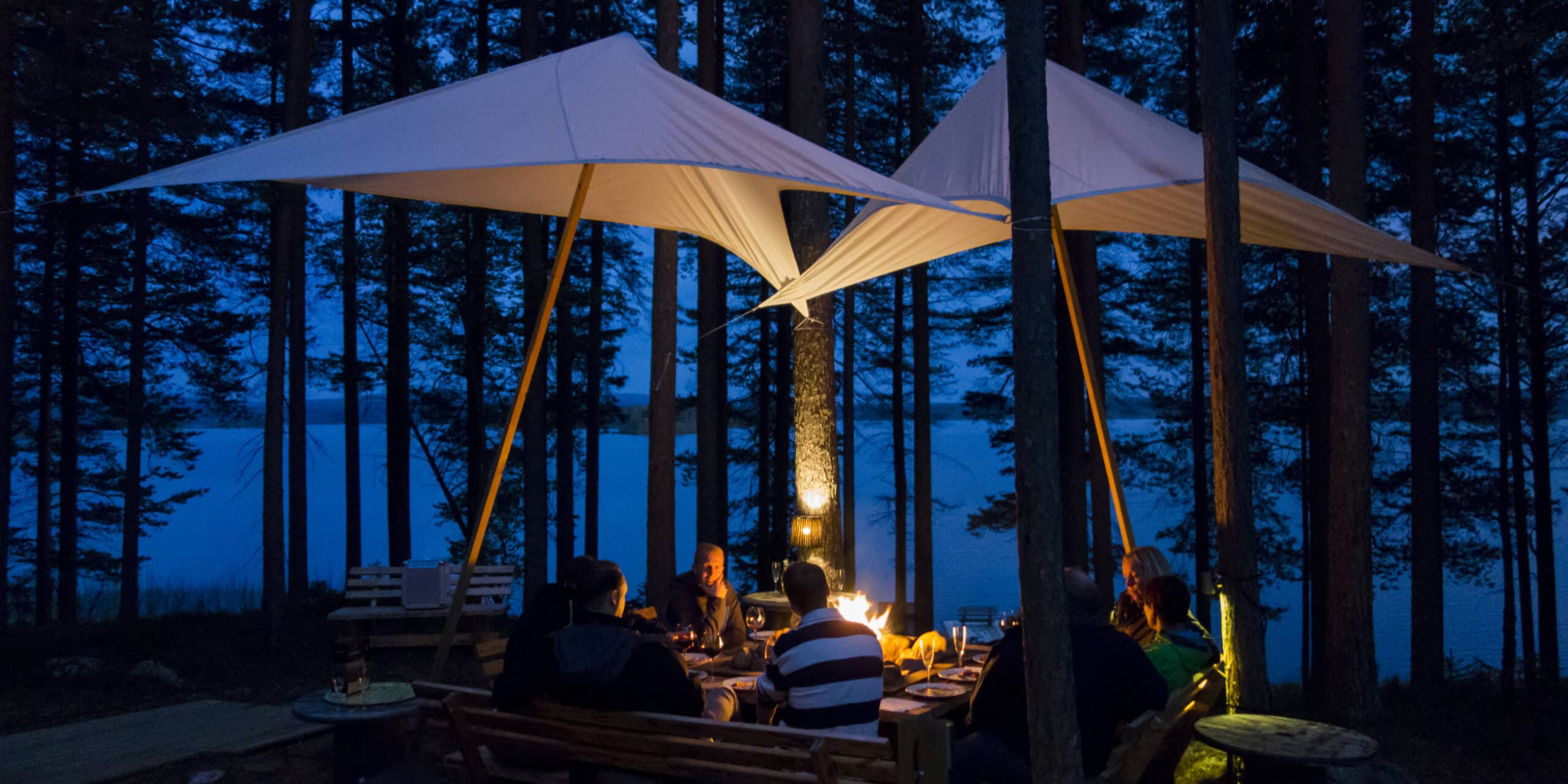 Photo de nuit d'un repas en extérieur au Aurora Safari Camp en Suède.