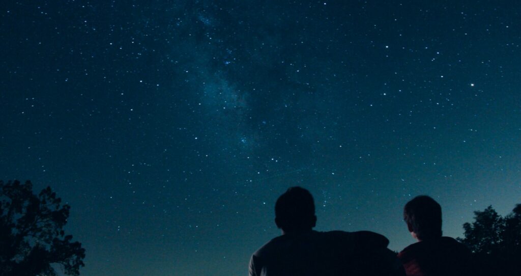 Deux personnes observent les étoiles par une nuit claire dans le désert d'Atacama au Chili.