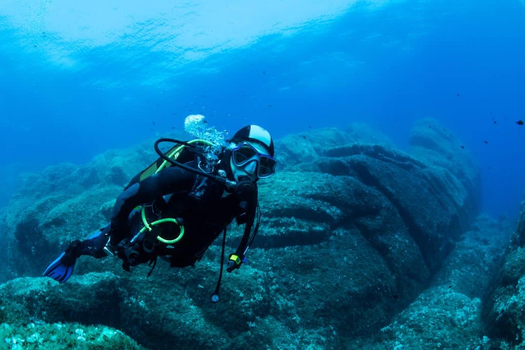 Woman,Scuba,Diving,Over,Rocks,In,The,Mediterranean,Sea