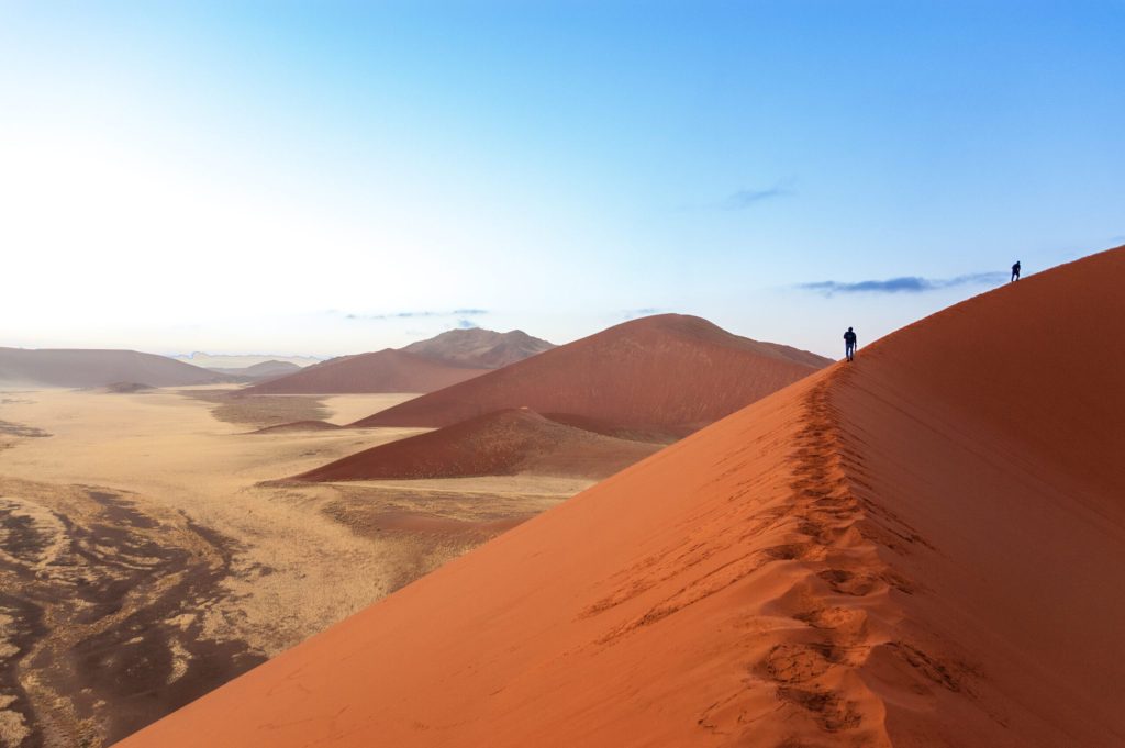 Randonnée sur les dunes ocres du désert du Sossusvlei en Namibie.