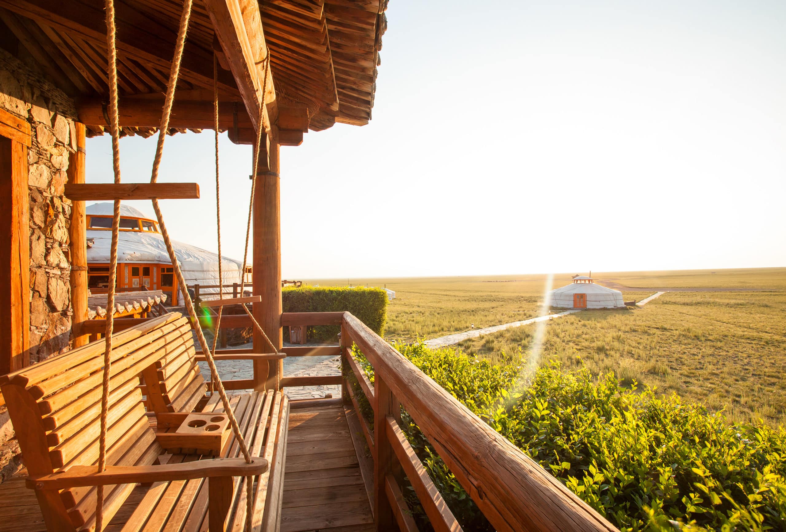 Terrasse privée d'une chambre devant une yourte du Three Camel Lodge en Mongolie.