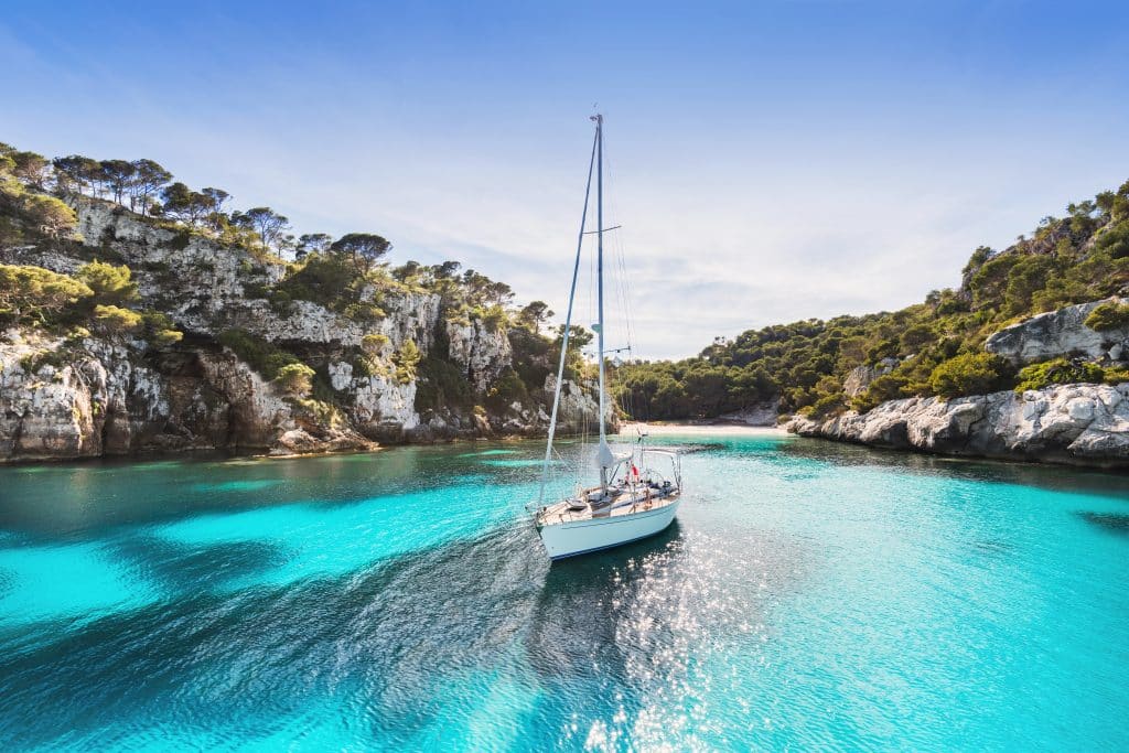 Beautiful,Beach,With,Sailing,Boat,Yacht,,Menorca,Island,,Spain.,Yachting,
