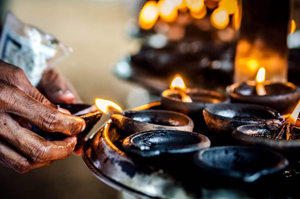 A,Person,Lights,A,Candle,In,A,Buddhist,Temple.,Kalutara.