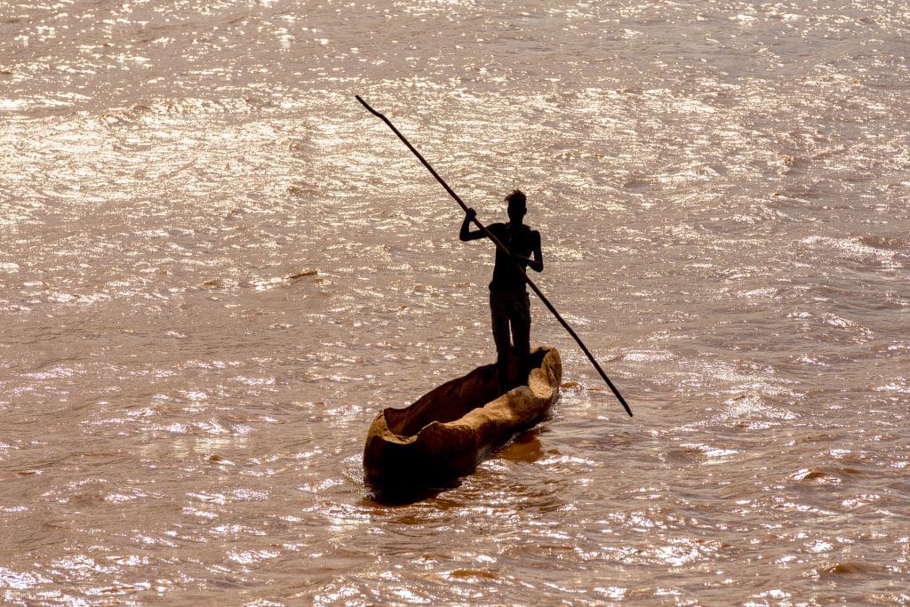 Silhouette,Of,A,Man,Paddling,On,A,Traditional,Coarse,Wooden