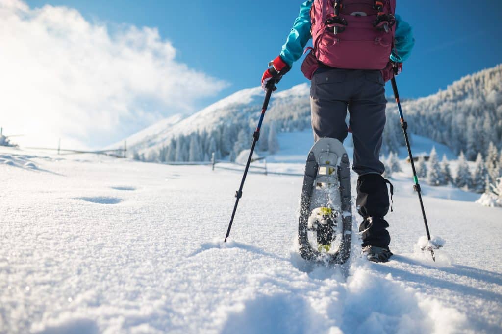 A,Woman,With,A,Backpack,In,Snowshoes,Climbs,A,Snowy