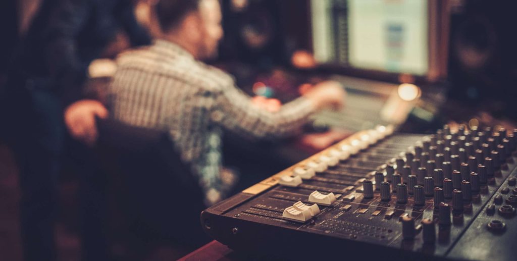 Sound,Engineer,And,Producer,Working,Together,At,Mixing,Panel,In