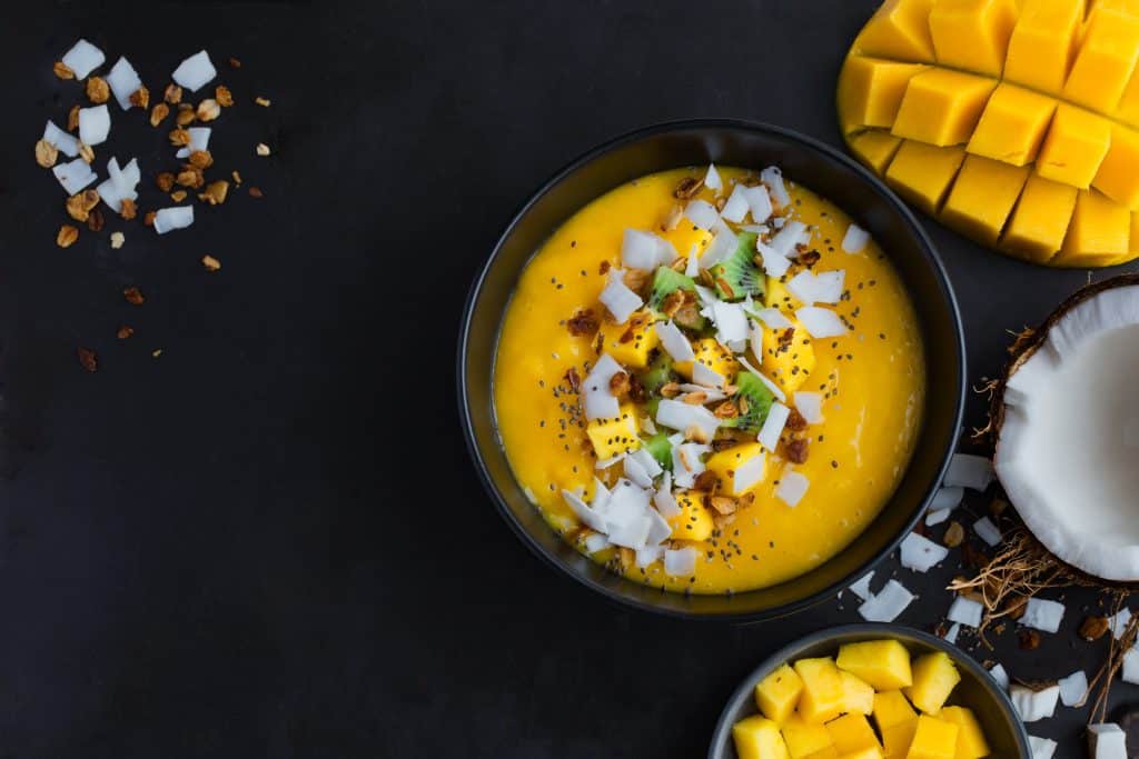 Fresh,Mango,And,Coconut,Smoothie,Bowl,On,Black,Background,,Top