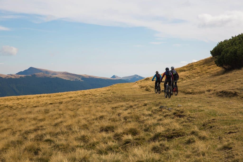 Cyclists,Riding,Through,Mountain,Landscape,In,Transylvania