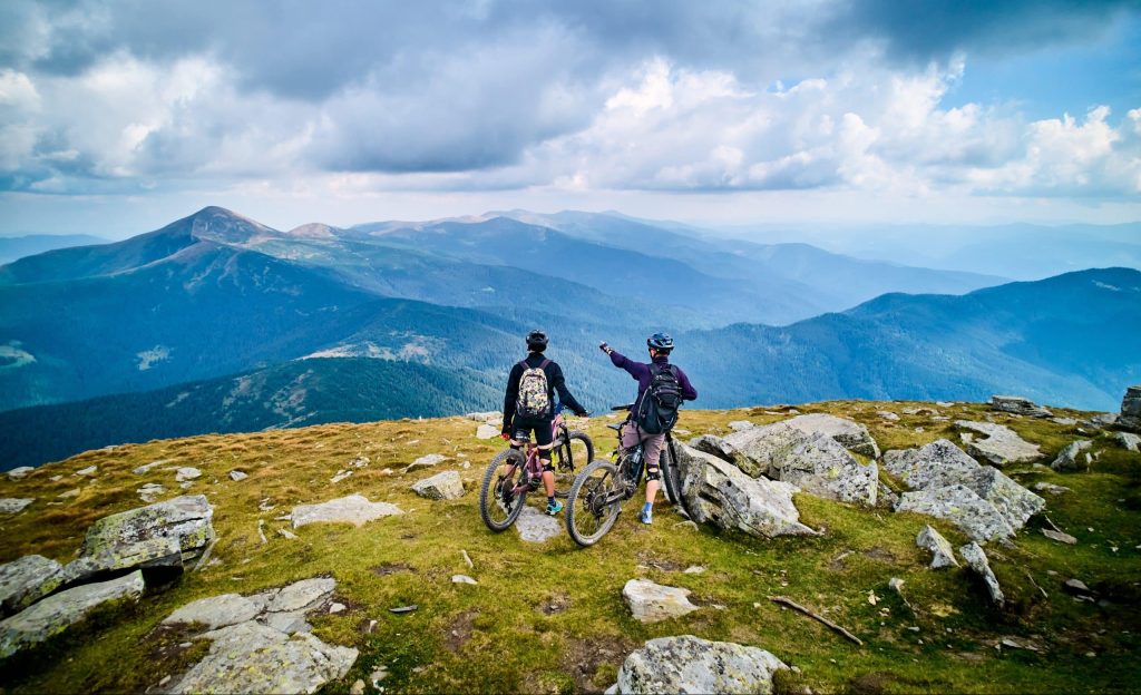 Two,Cyclists,Men,Riding,Electric,Bikes,Outdoors.,Back,View,Of